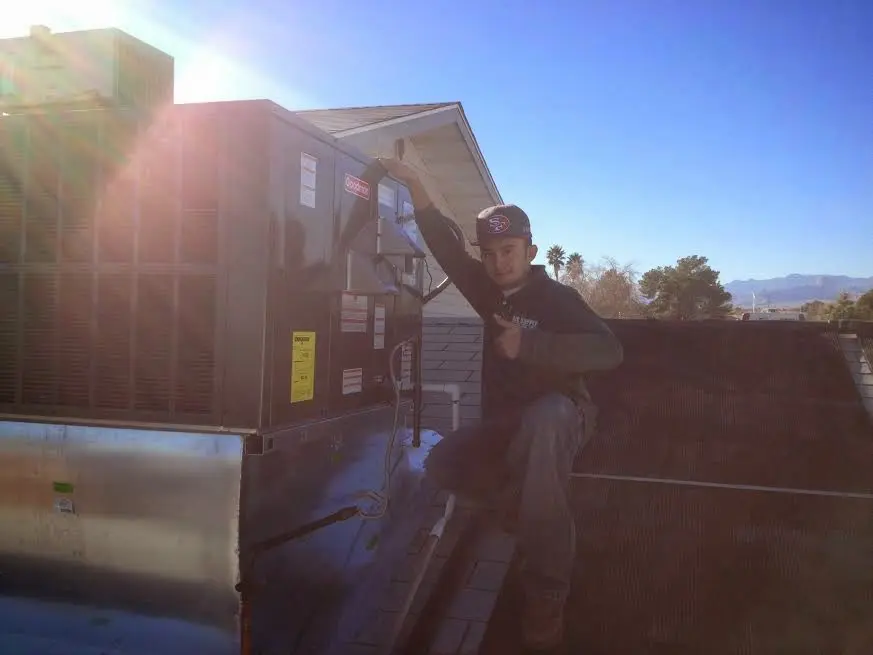 HVAC technician performing AC Tune-Up on a rooftop unit in Superior